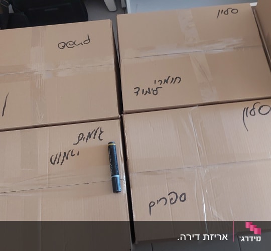 ארגזים עם כיתוב בעברית על רצפה